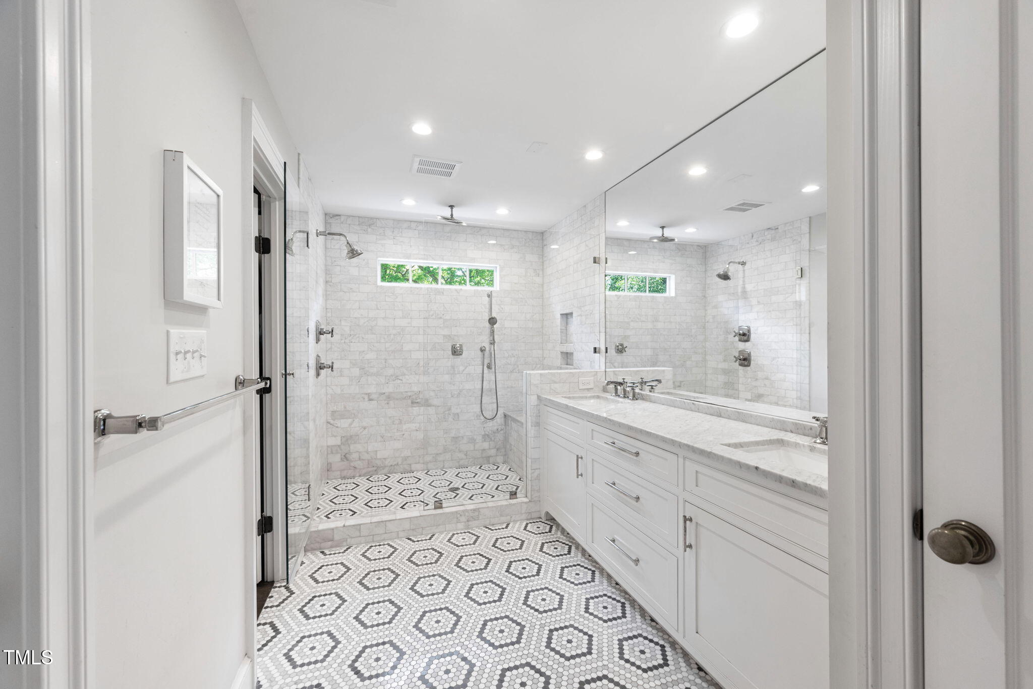 1619 Craig Street Raleigh, NC 27608 - Photo 25 of 49 a bathroom with a glass door shower a sink and a mirror