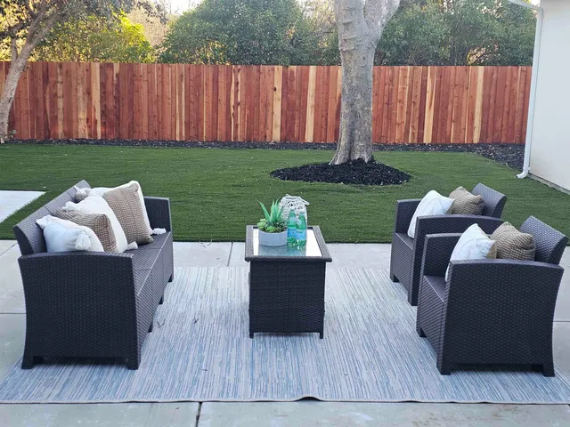 a view of a backyard with table and chairs and wooden fence