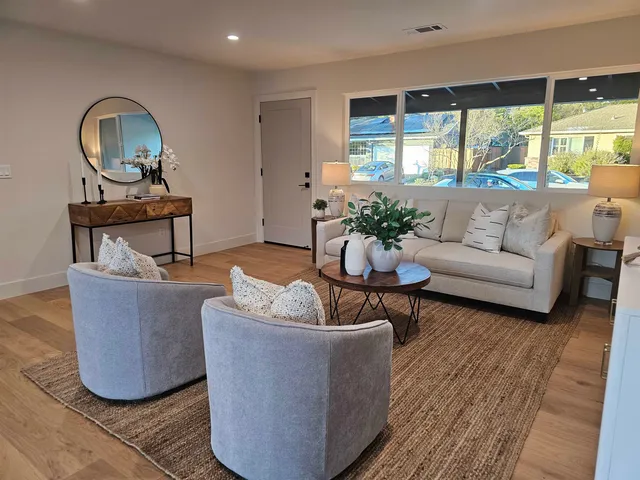 a living room with furniture a rug and a large window