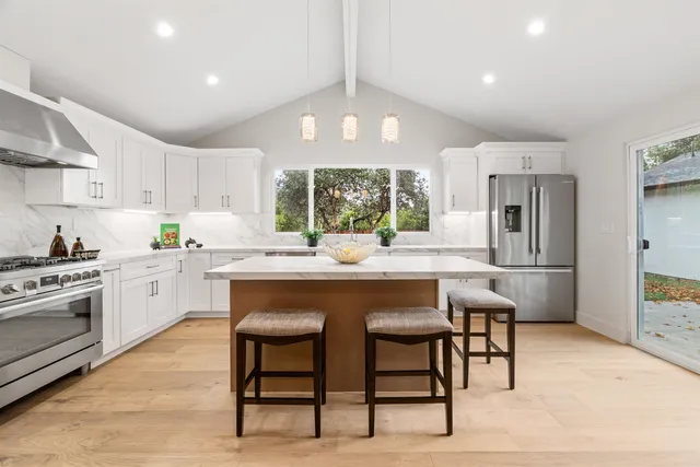 a kitchen with a table chairs sink and cabinets