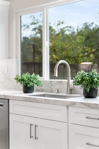 a kitchen with stainless steel appliances granite countertop a stove top oven a sink dishwasher and cabinets with wooden floor