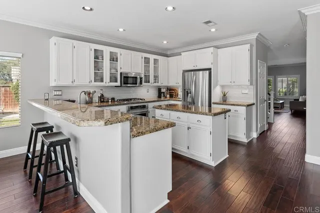 a kitchen with stainless steel appliances granite countertop a sink stove and refrigerator