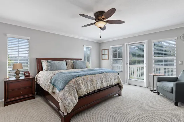 a spacious bedroom with a bed a couch and a large window