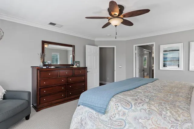 a bedroom with a bed a chandelier and a dresser