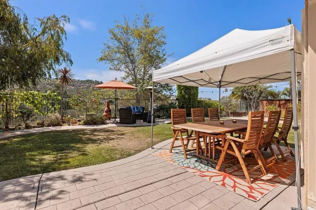 a view of a patio with a table and chairs under an umbrella