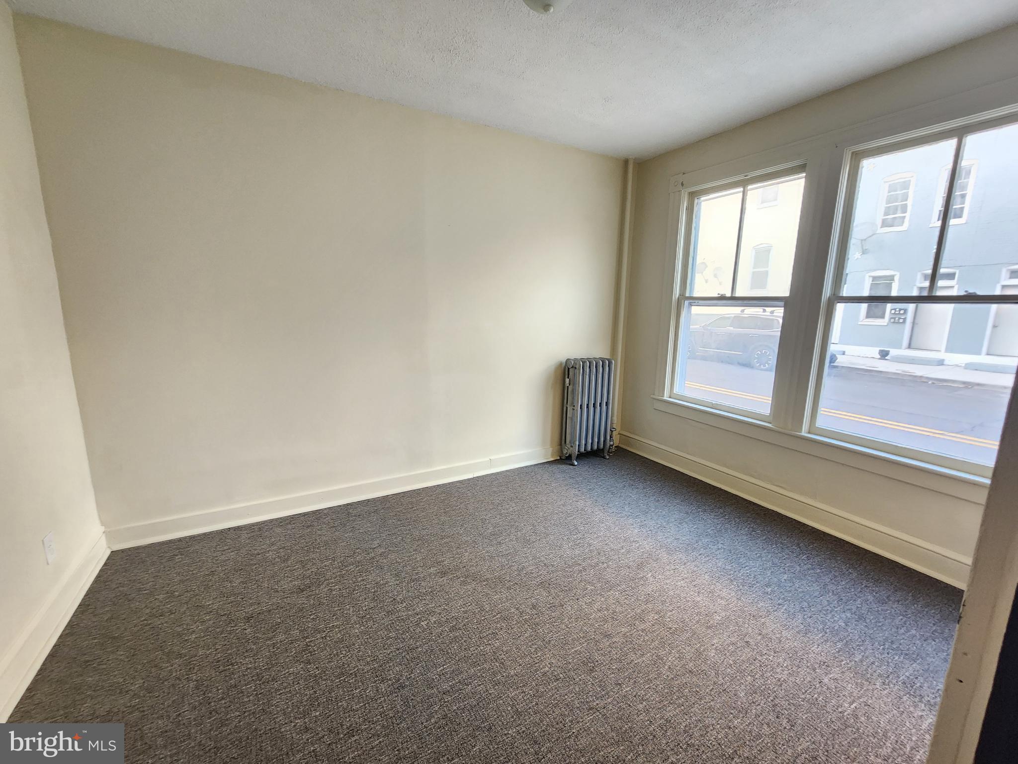 105 Park Street Cumberland, MD 21502 - Photo 2 of 18 an empty room with a fireplace