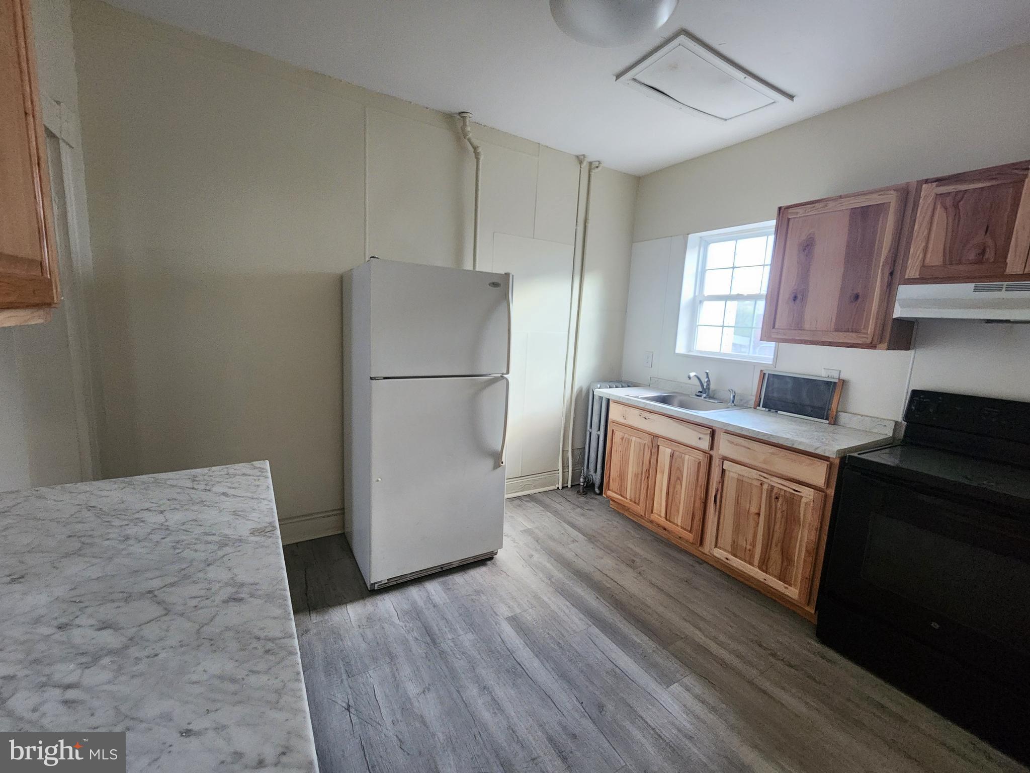 105 Park Street Cumberland, MD 21502 - Photo 5 of 18 a kitchen with a refrigerator a sink and dishwasher