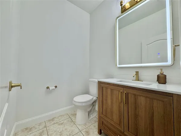 a bathroom with a granite countertop sink a toilet and a mirror