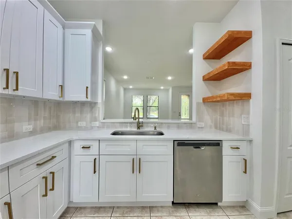 a kitchen with white cabinets and sink