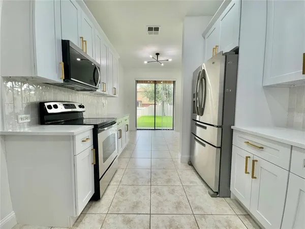 a kitchen with stainless steel appliances a refrigerator sink and microwave