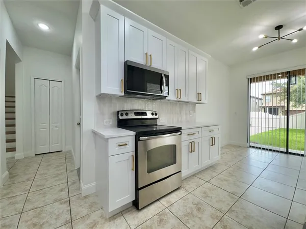 a kitchen with stainless steel appliances granite countertop a stove a sink and a microwave
