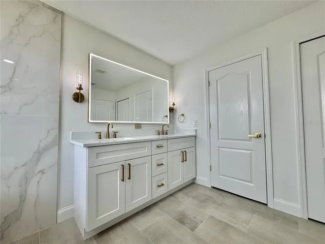a spacious bathroom with a double vanity sink and a mirror