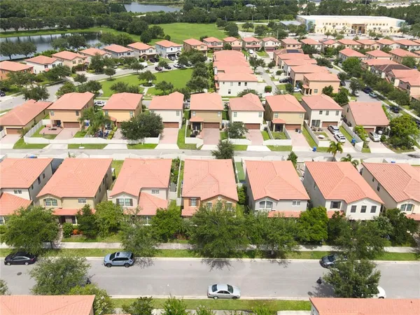 an aerial view of residential houses with outdoor space and lake view