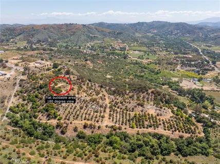 an aerial view of house with yard and mountain view in back