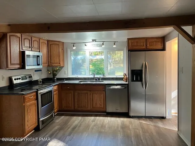 a kitchen with stainless steel appliances granite countertop a refrigerator a sink and a stove