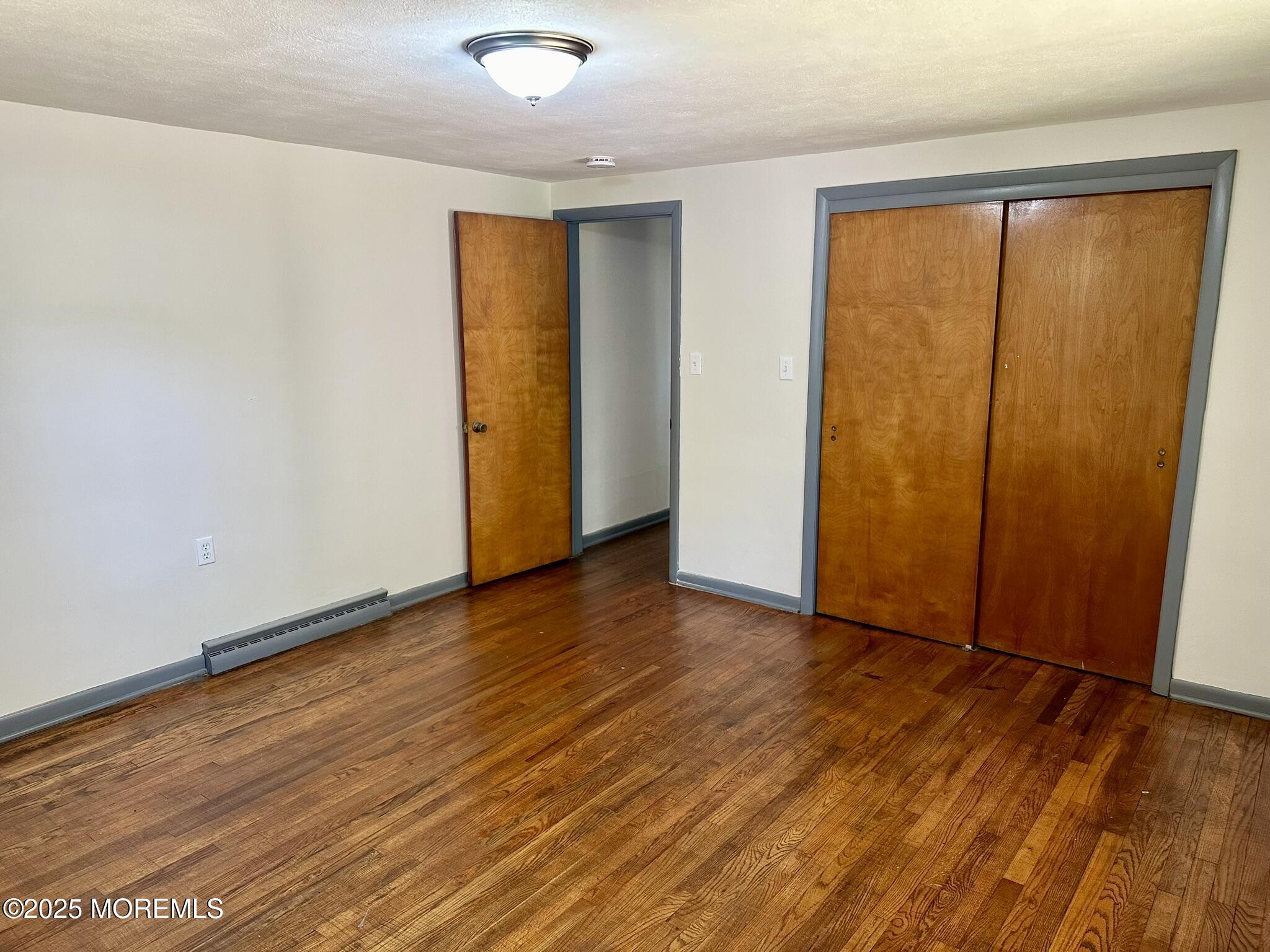 135 South Main Street Barnegat, NJ 08005 - Photo 11 of 35 an empty room with wooden floor and sliding door