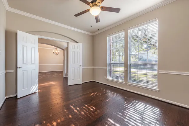 a view of an empty room with window and wooden floor