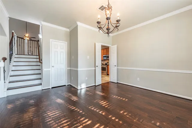 a view of a livingroom with wooden floor and staircase
