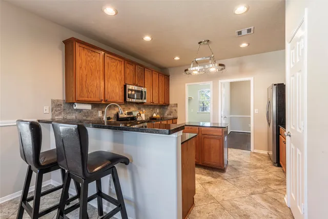 a kitchen with granite countertop wooden cabinets and stainless steel appliances