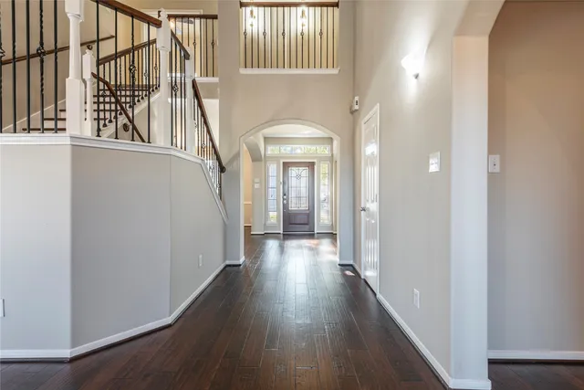 a view of a hallway with wooden floor and staircase