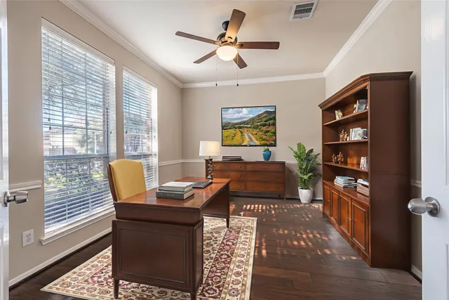 a living room with furniture a bookshelf and a window