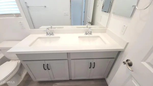a bathroom with a sink a toilet and a mirror