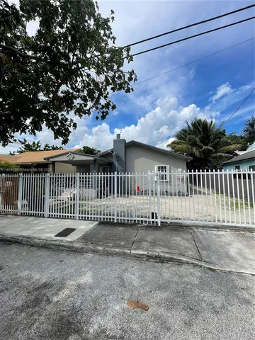 a view of a house with a small yard and wooden fence