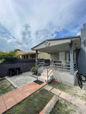 a view of a house with a yard and furniture