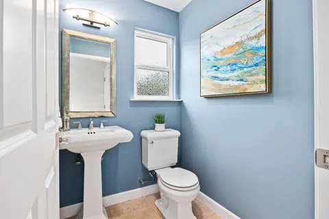 a bathroom with a toilet a sink and mirror