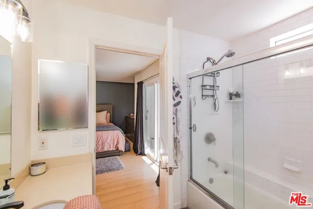 a bedroom with a bed and large windows