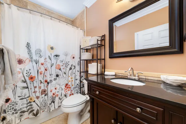 a bathroom with a granite countertop sink and a toilet