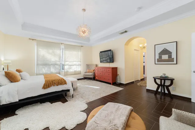 a spacious bedroom with two beds and a chandelier