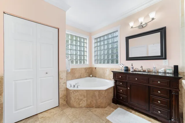 a bathroom with a tub a sink and mirror