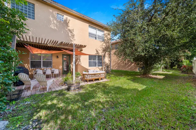 a view of a house with backyard and sitting area