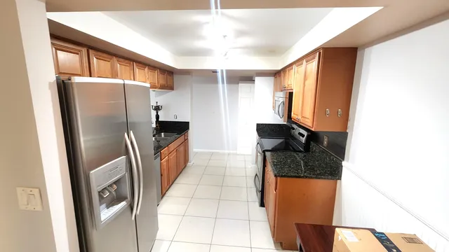 a kitchen with stainless steel appliances granite countertop a refrigerator and a sink