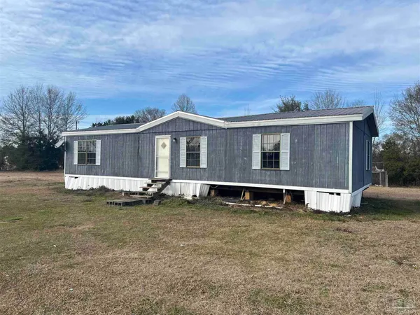 a view of a house with a yard and sitting area
