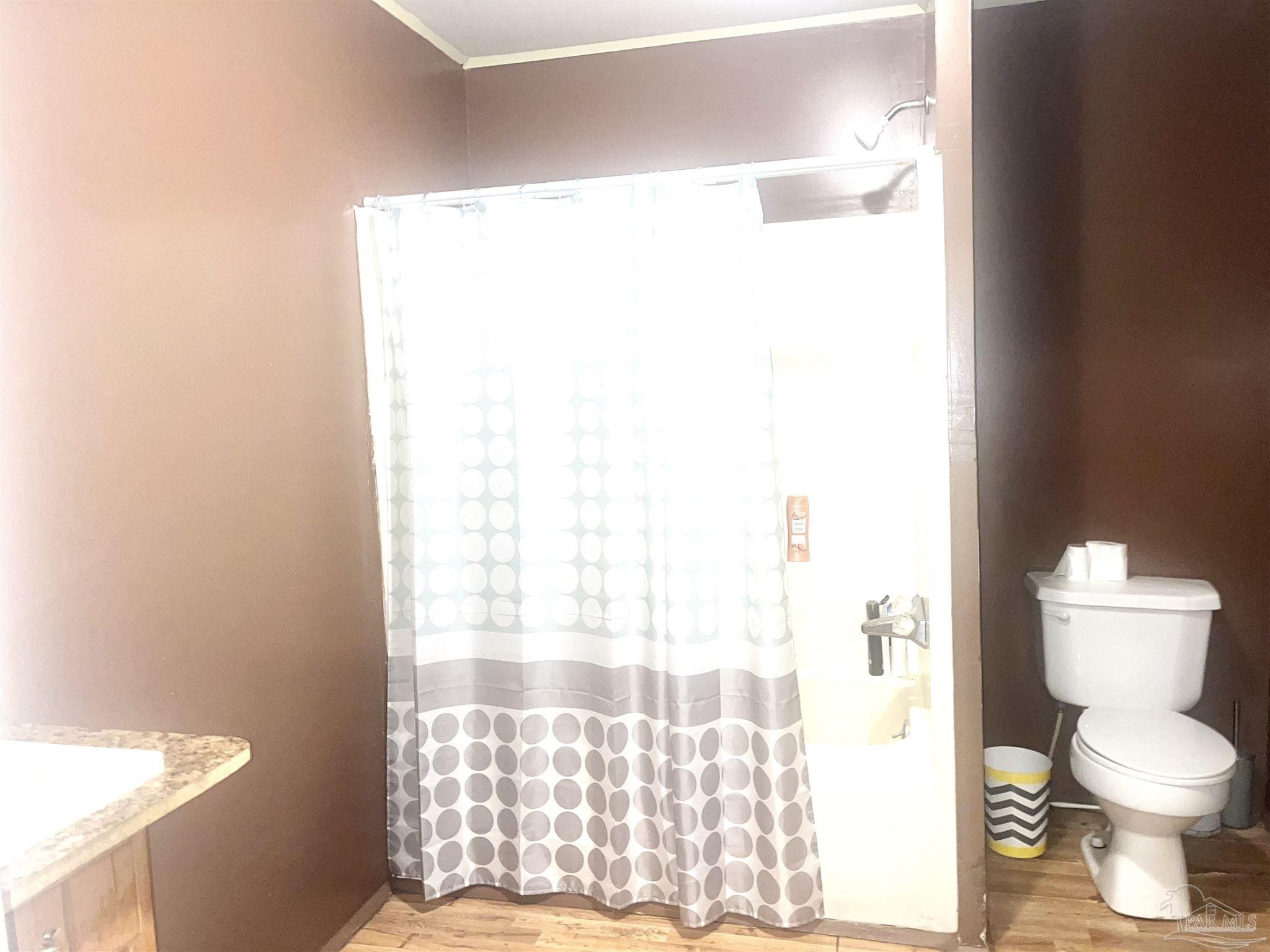 1482 Smith Dairy Road Atmore, AL 36502 - Photo 10 of 34 a bathroom with a toilet and a shower curtain