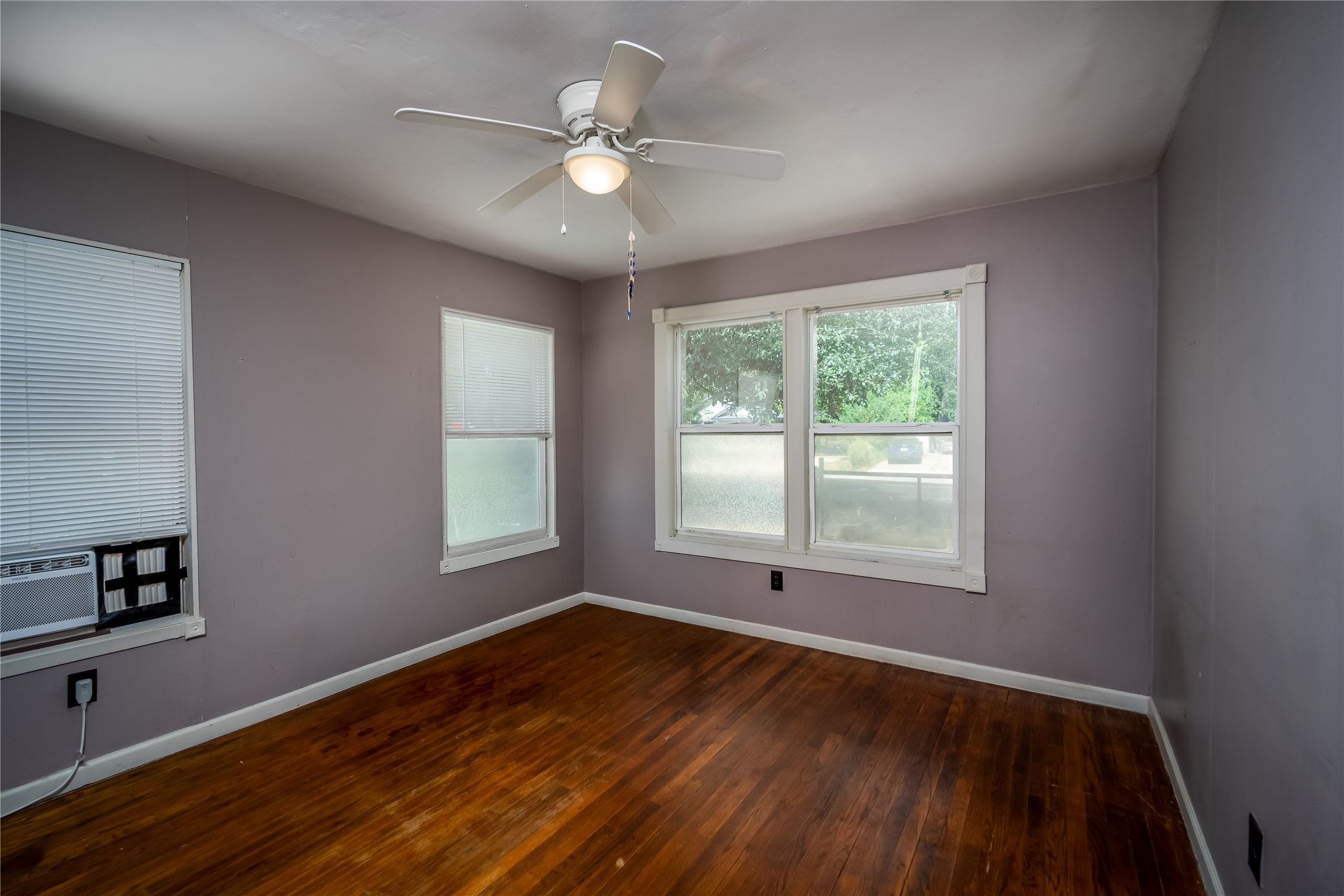 719 Springdale Road Austin, TX 78702 - Photo 11 of 17 Well-lit interior space with rich hardwood flooring and a functional ceiling fan.