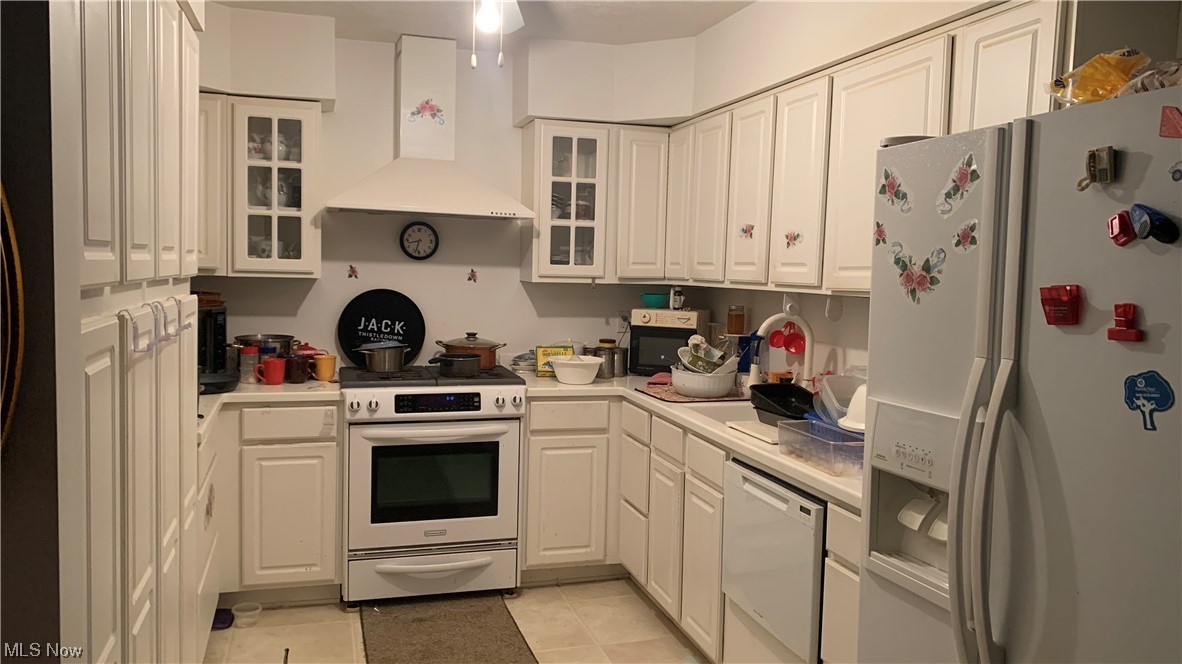 18375 Alexander Road Walton Hills, OH 44146 - Photo 11 of 25 Kitchen featuring exhaust hood, white cabinetry, white appliances, and light tile floors