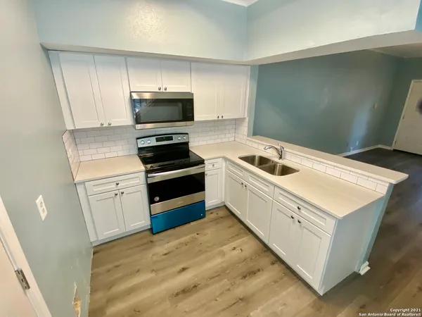 a kitchen with white cabinets and stainless steel appliances