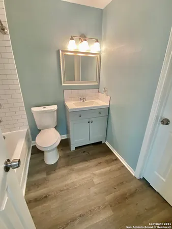 a bathroom with a toilet sink and mirror