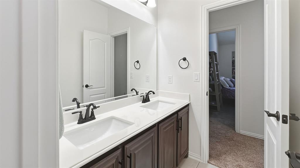 5216 Troupe Road McKinney, TX 75071 - Photo 35 of 40 Double vanity featuring undermount sinks, white countertops, dark wood-finish cabinetry, and matte black fixtures