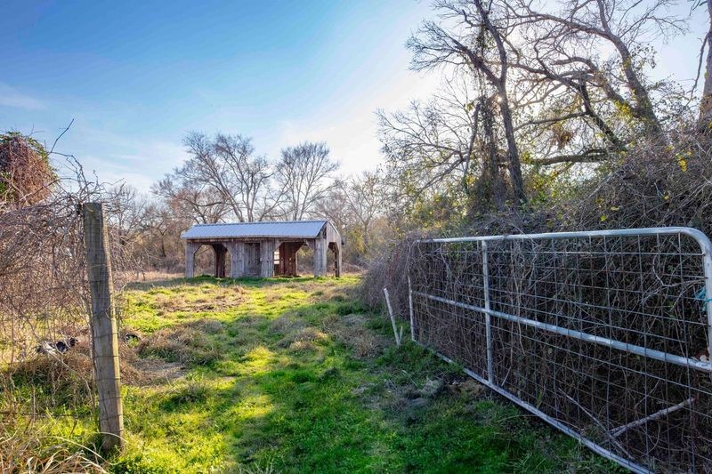 38241 Wiggins Road Hempstead, TX 77445 - Photo 45 of 48 a view of a backyard with wooden fence and large trees