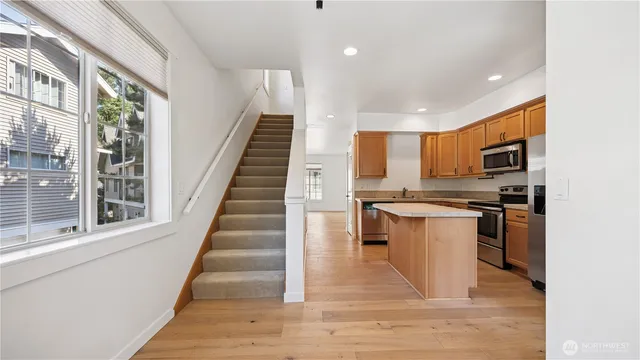 a kitchen with stainless steel appliances kitchen island granite countertop a refrigerator and a stove top oven