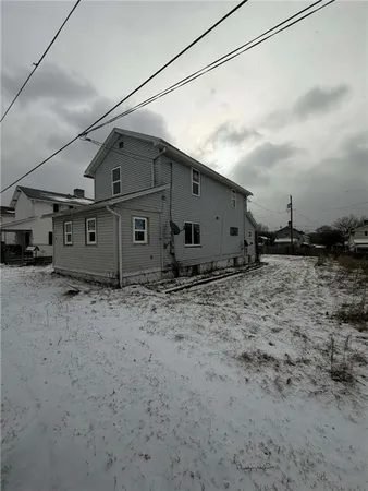 a view of a big house with wooden fence