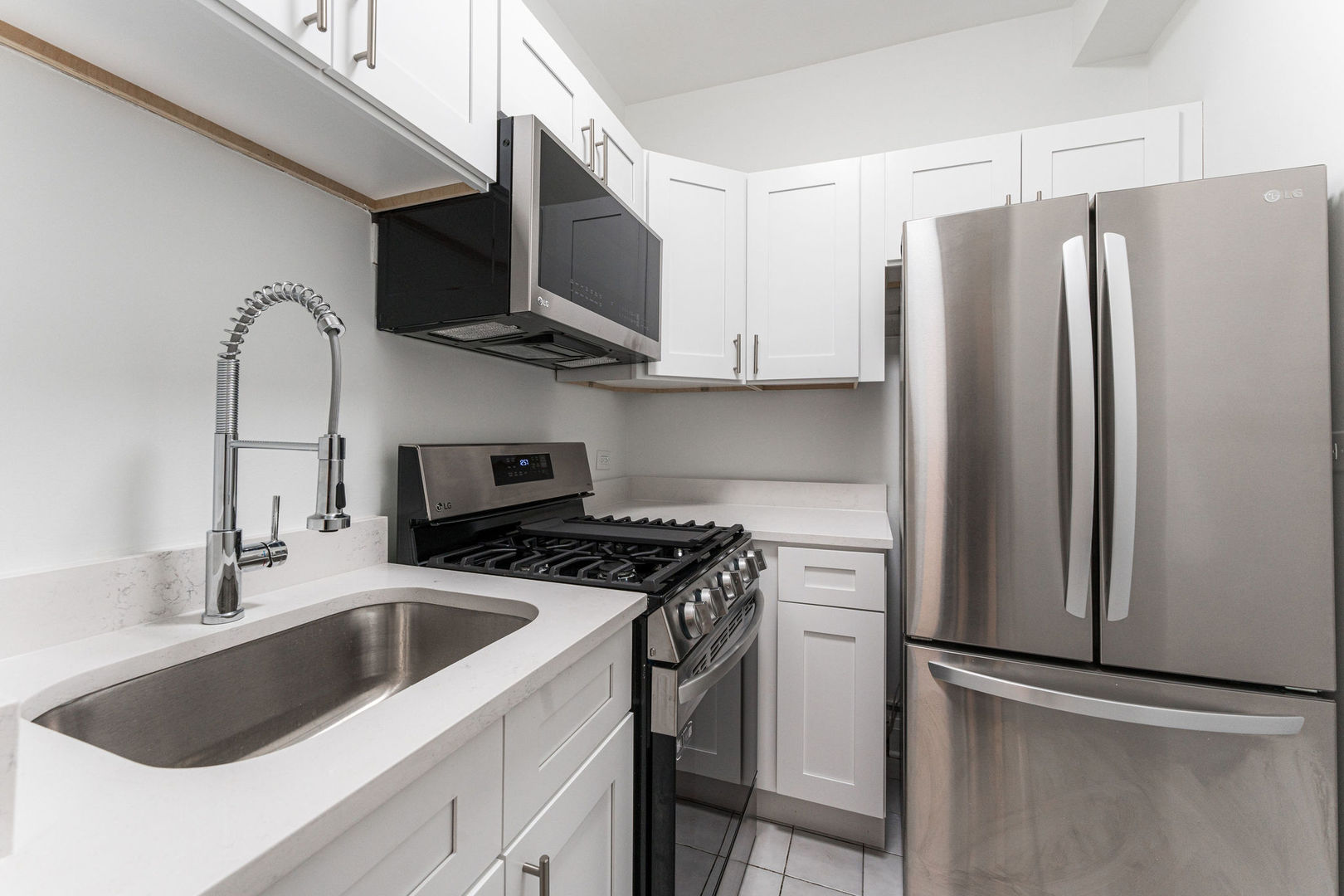 6101 North Sheridan Road, Unit 8G Chicago, IL 60660 - Photo 5 of 15 a kitchen with stainless steel appliances a refrigerator a sink and white cabinets