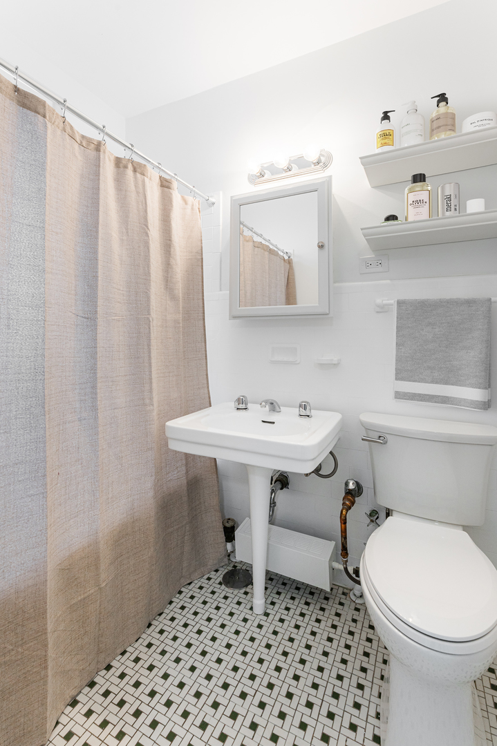 6101 North Sheridan Road, Unit 8G Chicago, IL 60660 - Photo 9 of 15 a bathroom with a sink a toilet and shower