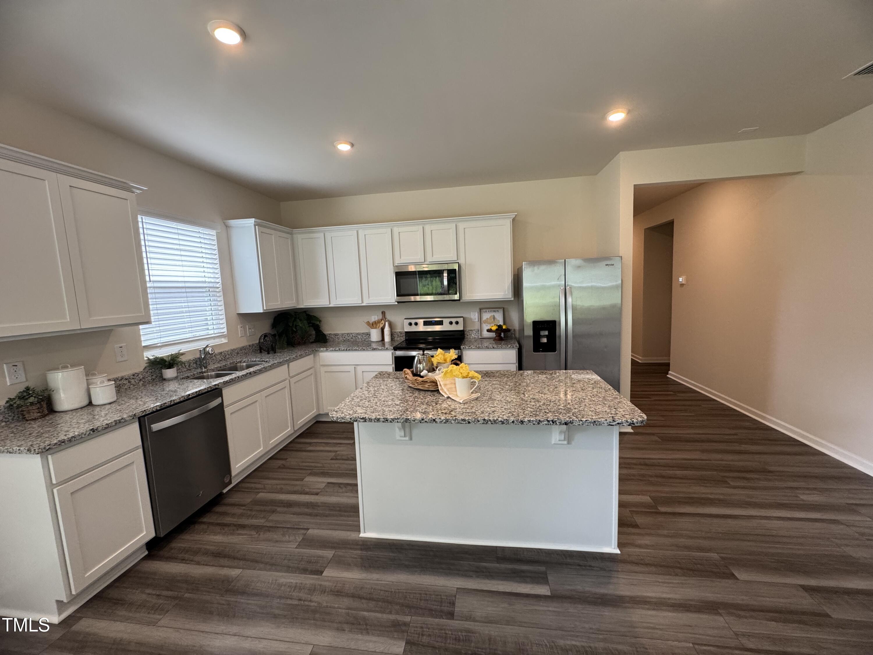 1444 Heron Pond Street Raleigh, NC 27604 - Photo 33 of 37 a kitchen with granite countertop wooden cabinets and a refrigerator