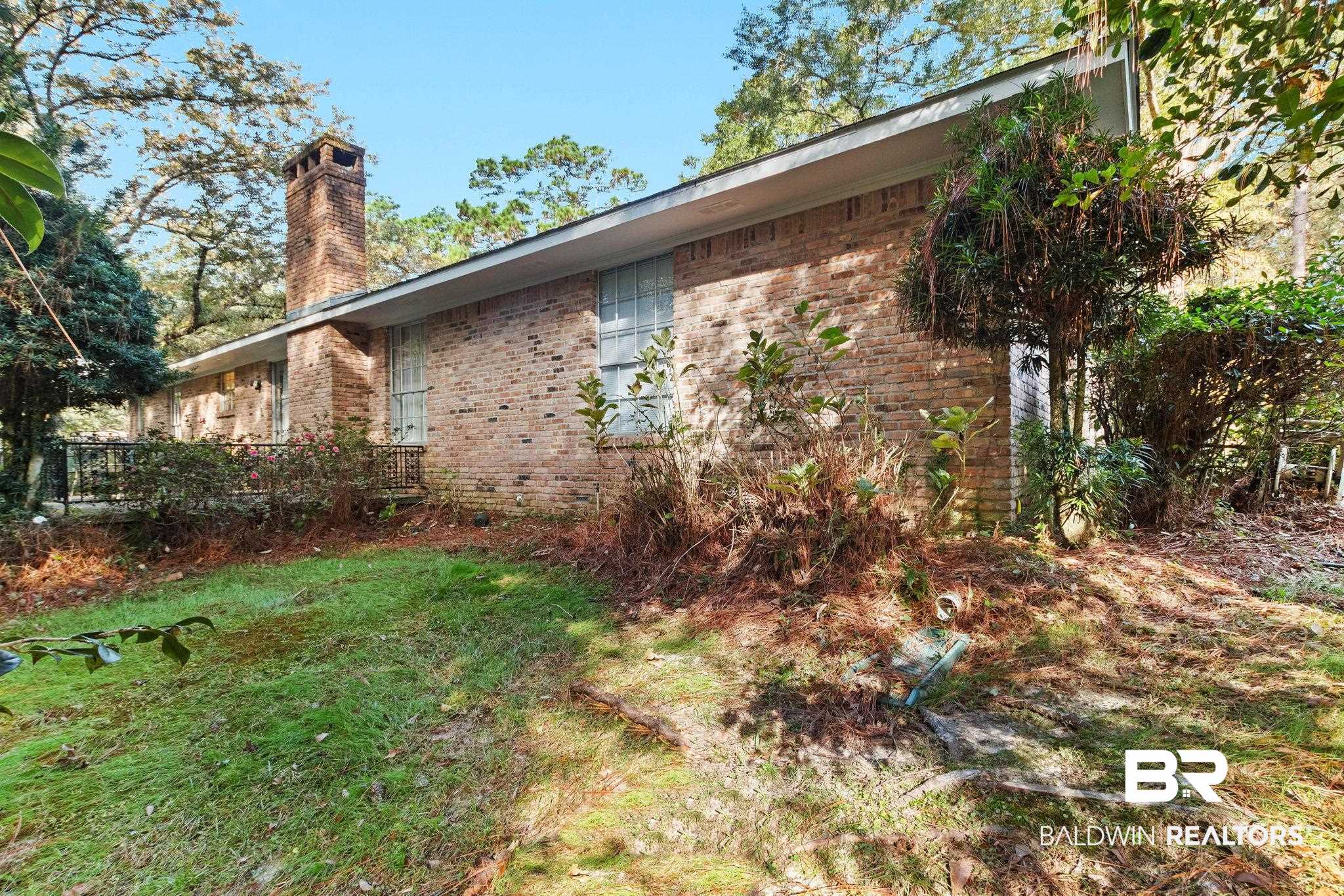 752 Evergreen Street Fairhope, AL 36532 - Photo 74 of 100 View of side of property featuring a chimney, brick siding, and a wooden deck