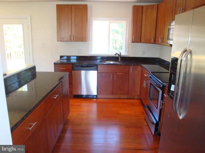 3702 Stonesboro Road Fort Washington, MD 20744 - Photo 3 of 8 a kitchen with granite countertop a sink and a stove top oven